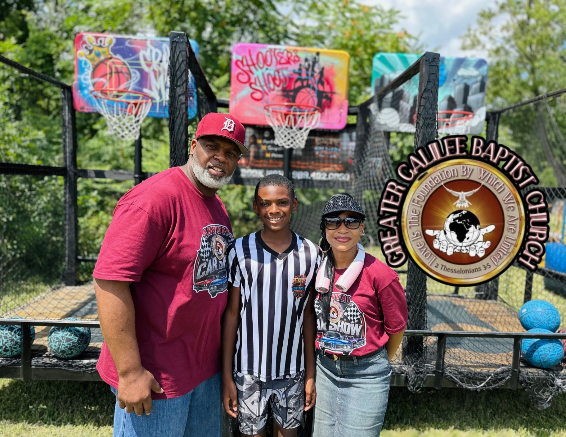Side By Side Mobile Hoops team with a family at the Greater Galilee Baptist Church annual car show, three airbrushed backboards behind them.
